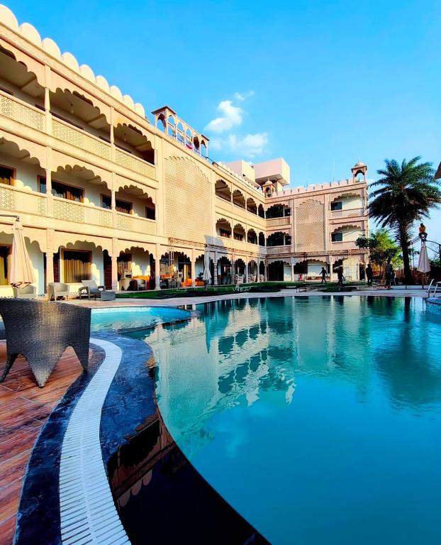 a large swimming pool in front of a building at Shiv Resort & Palace in Shivpurī