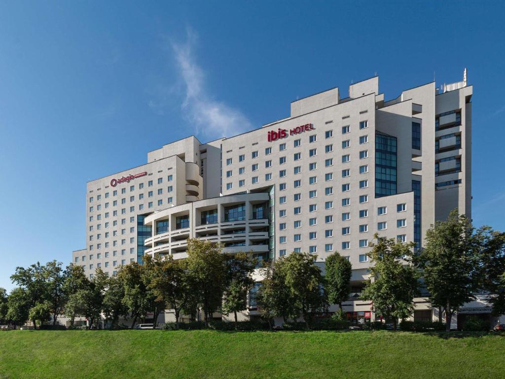 a large white building with a hill in front of it at ibis Kyiv Beresteiska in Kyiv