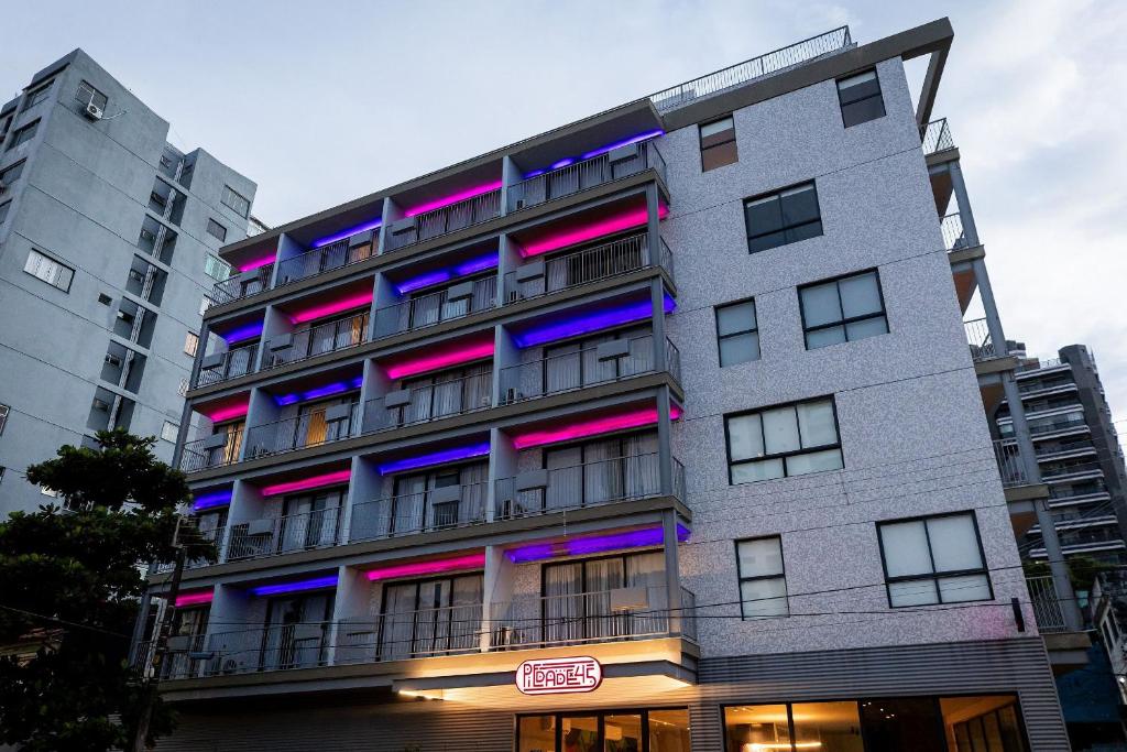 a building with pink and purple lights on it at Studio Piedade 45 | More do seu jeito in Belém