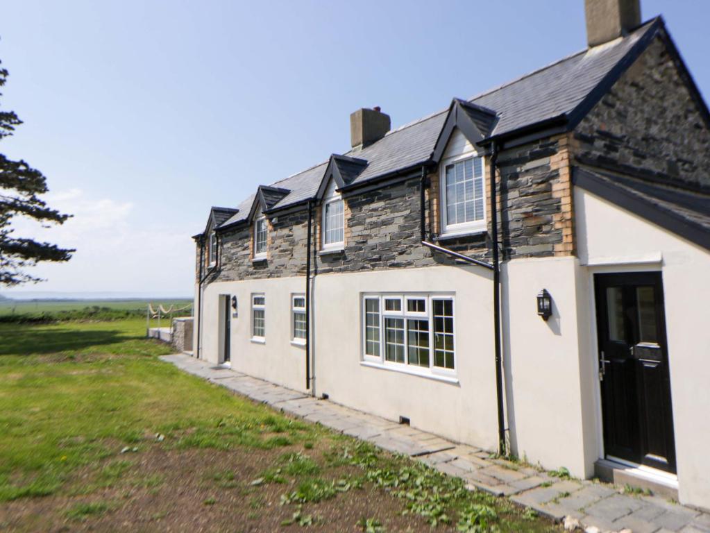 an old cottage with a view of the ocean at Rosemary Cottage 1 in Tywyn