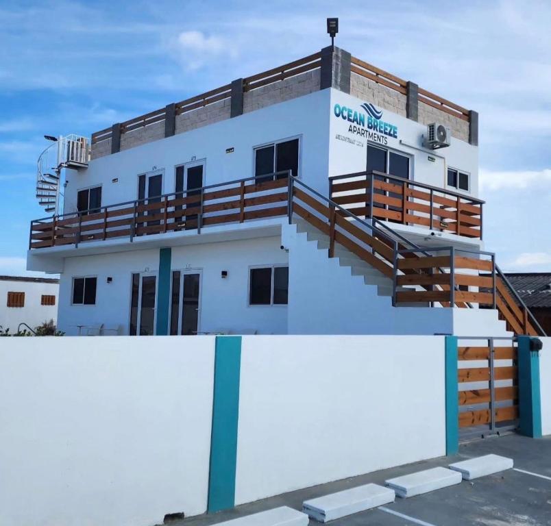 a white building with stairs and a balcony at Ocean Breeze in Oranjestad