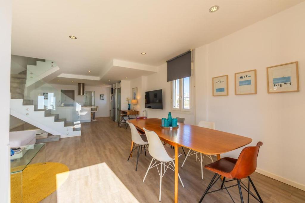 a dining room and living room with a table and chairs at Caracolas Luxury House Duplex in Tarifa