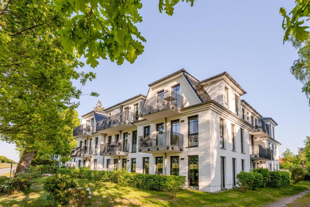 an exterior view of a large white building with balconies at Strandhaus Zingst Apartment 15 in Zingst