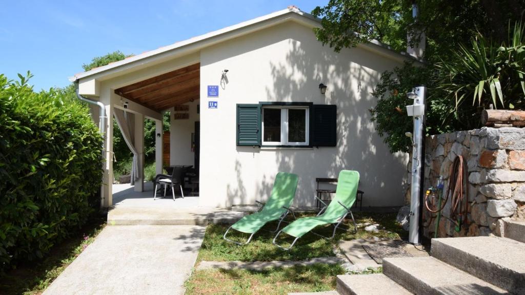 two green chairs sitting outside of a house at Villa Skala by Villas Guide in Novi Vinodolski