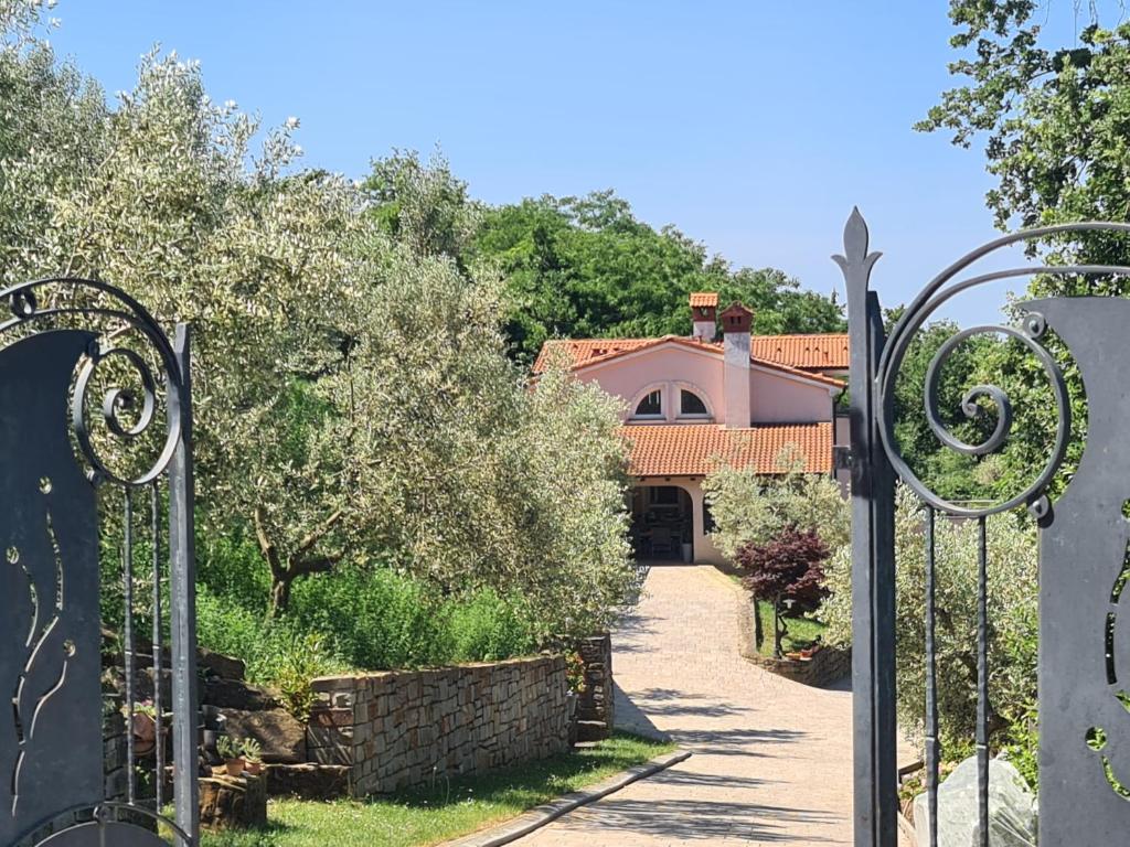 a gate in front of a house with a driveway at Alloro in Ankaran