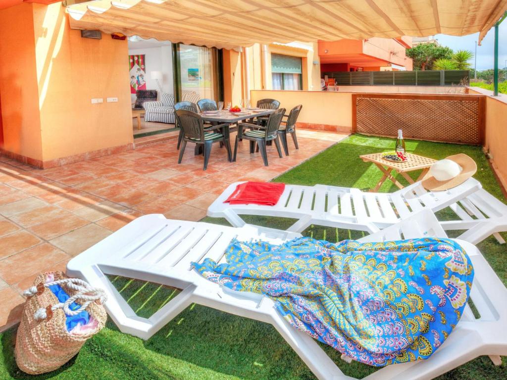 a group of white picnic tables on a lawn at Apartment Gardenia by Interhome in Lloret de Mar