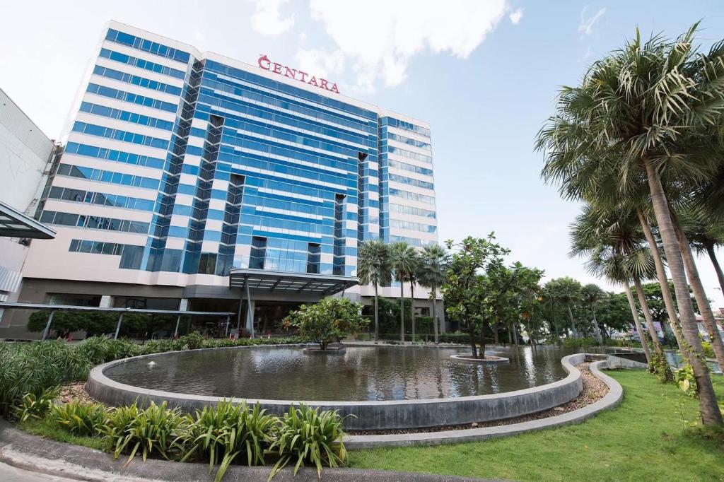 a building with a pond in front of it at Centara Udon in Udon Thani
