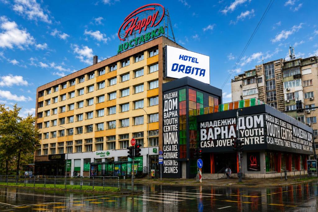 a building with signs on it in a city at Hotel Orbita in Varna City