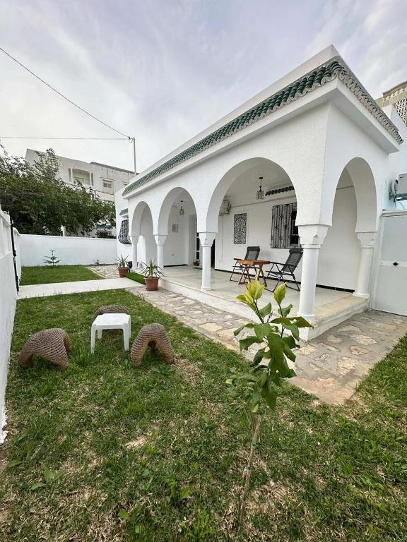 a white house with a bench in the yard at villa Flamingo in Sousse