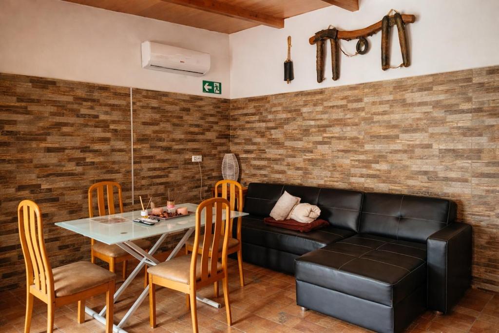 a living room with a black leather couch and a table at Casa El Filali in Villaminaya