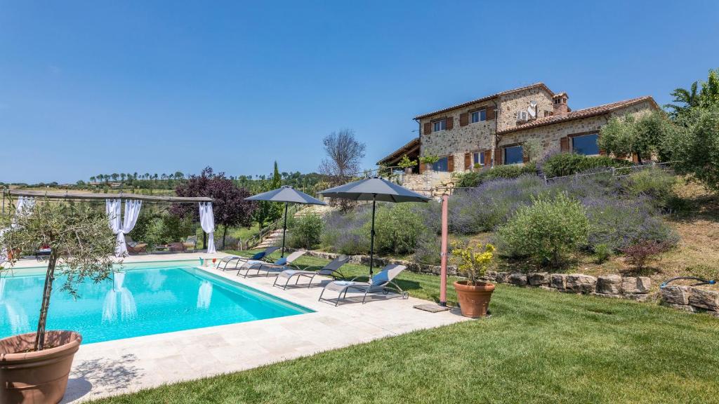 a swimming pool in the backyard of a house at CASALE DEI GELSOMINI 8, Emma Villas in Todi
