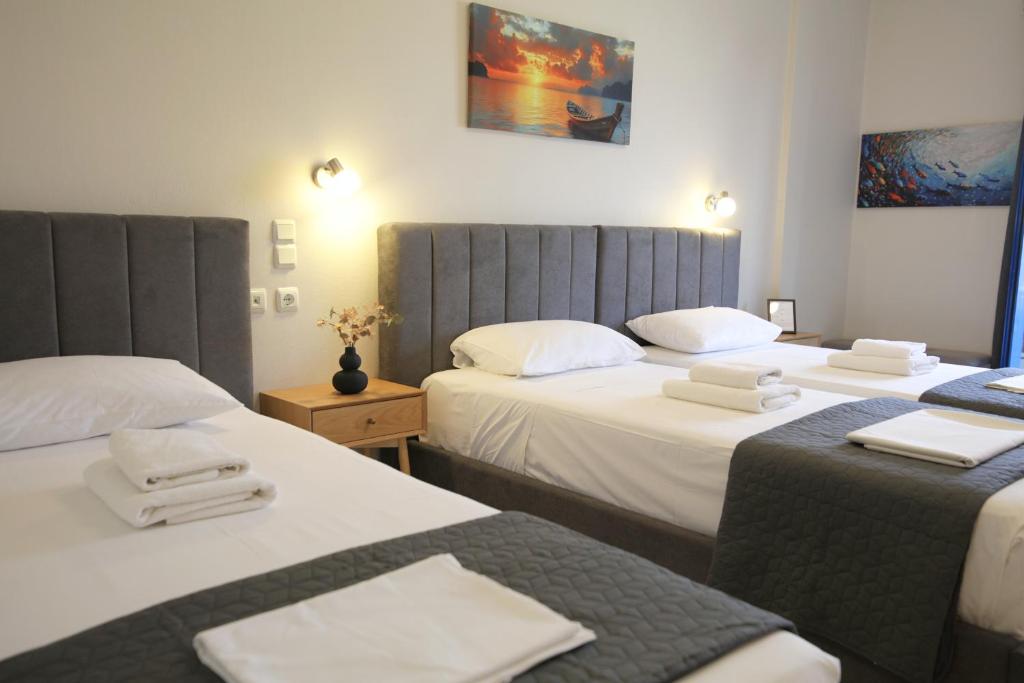 two beds in a hotel room with towels on them at Mochlos Studios in Mochlos