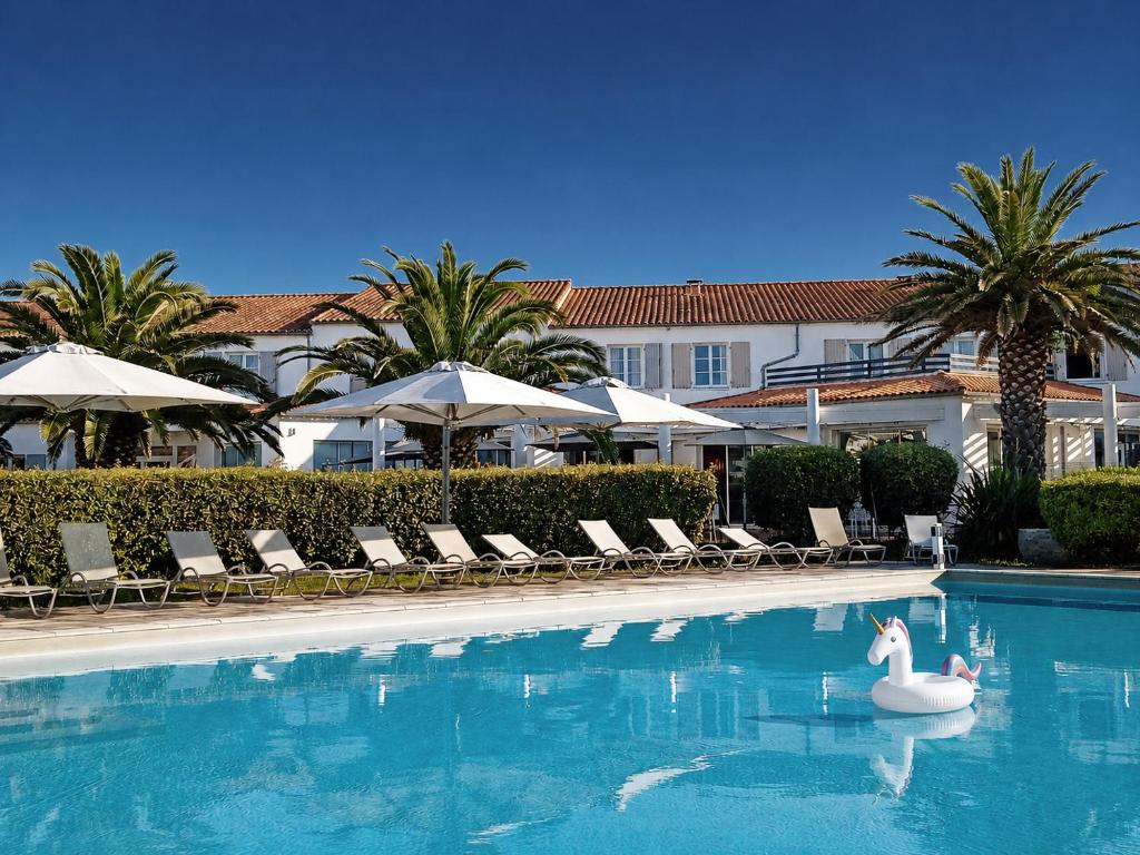 a swimming pool with two swans in the water at Thalacap Île de Ré - Thalasso & Spa in Ars-en-Ré