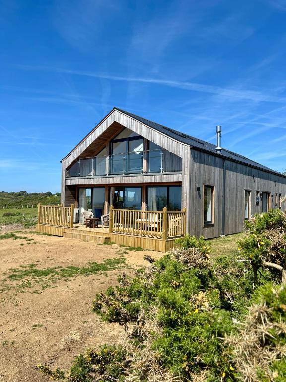 a large wooden house with a lot of windows at Pourquoi Pas B&B in Sark