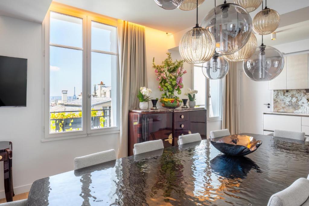 a dining room with a table and chairs and a window at Montmartre Residence in Paris