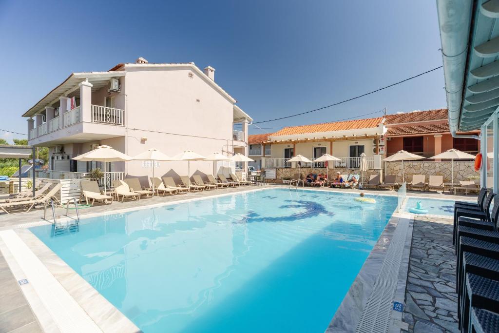 a swimming pool with chairs and umbrellas at a hotel at Spyridoula Resort in Corfu in Gouvia