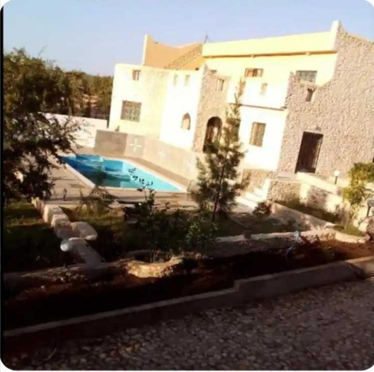 a large building with a swimming pool in front of it at Dar ojkak in Essaouira