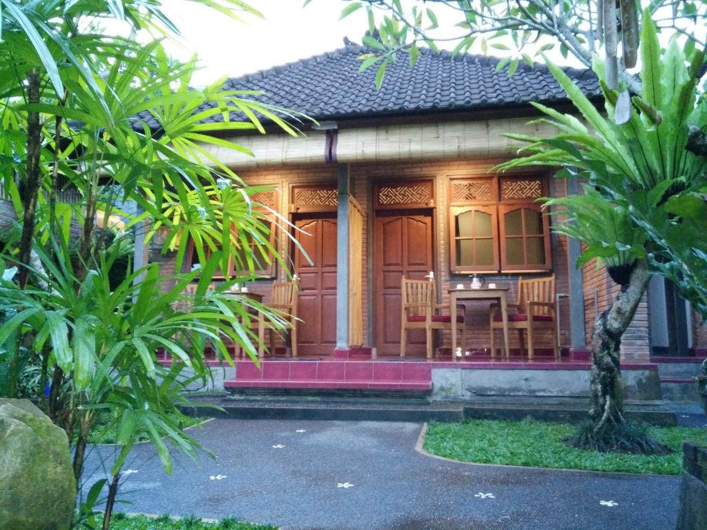 a house with a red door and some trees at Tara House in Ubud