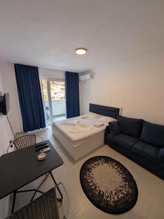 a living room with a bed and a couch at Studio apartment LISI 2 in Lezhë