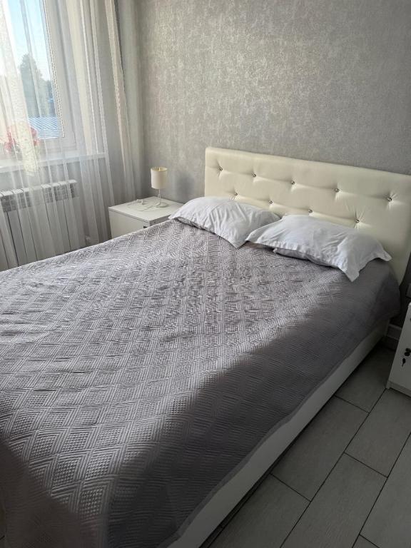 a large bed with a white headboard in a bedroom at Amari in Uralʼskiy Prigorodnyy