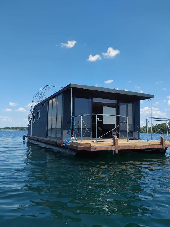 a house on a dock on the water at Bateau Lac du Der - Nuisement - Navigation in Les Petites-Côtes
