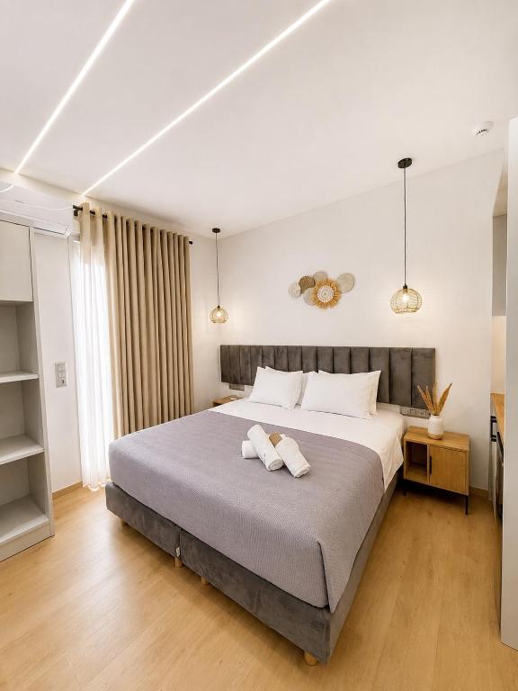 a bedroom with a large bed with two towels on it at Nefonas Guest House in Skiathos