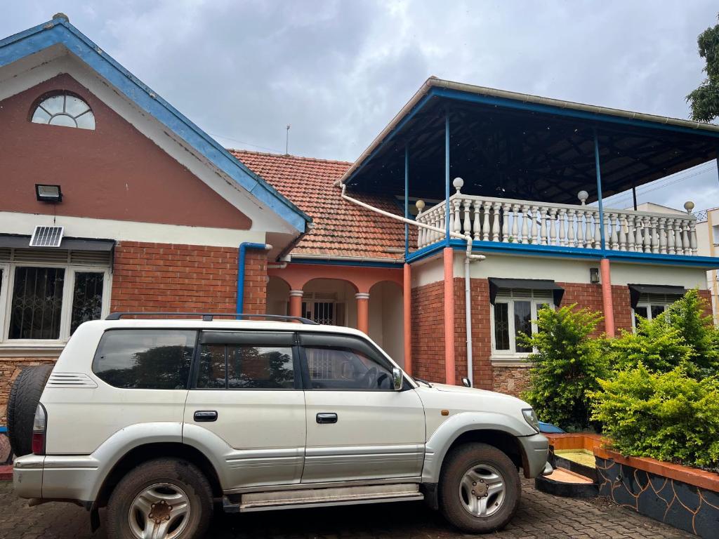 a white car parked in front of a house at Happy Fish Villa in Entebbe