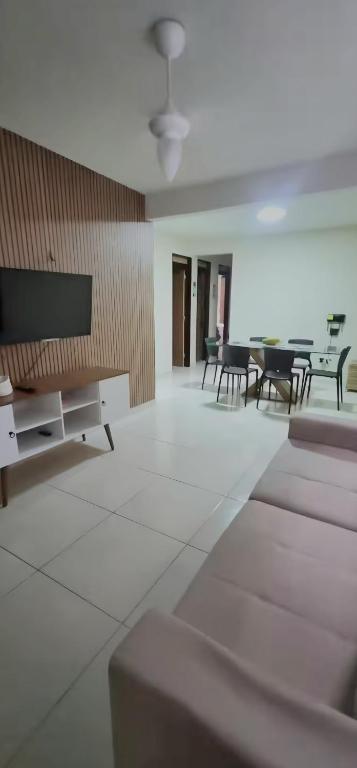 a living room with chairs and a flat screen tv at Intermares perto de tudo com 3 quartos in Cabedelo
