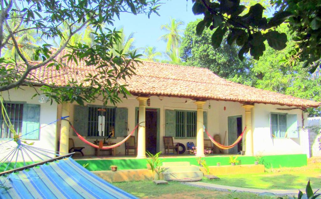 a house with a hammock in front of it at Mahagedara "Dream Villa" in Galle