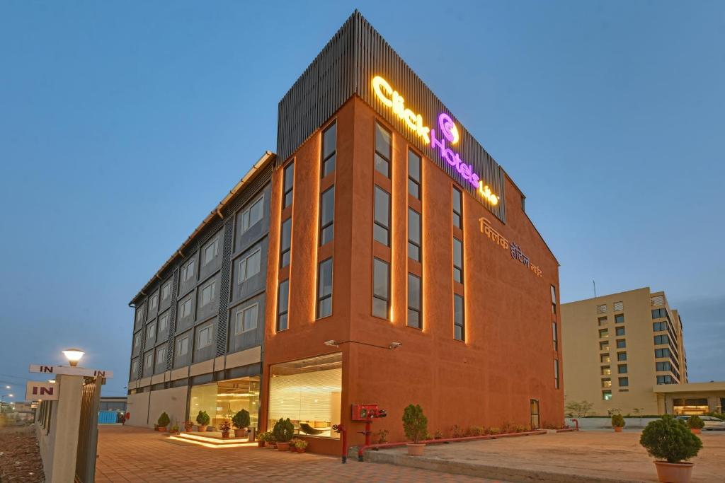 a building with a sign on the side of it at Click Hotels Lite Chakan in Pune