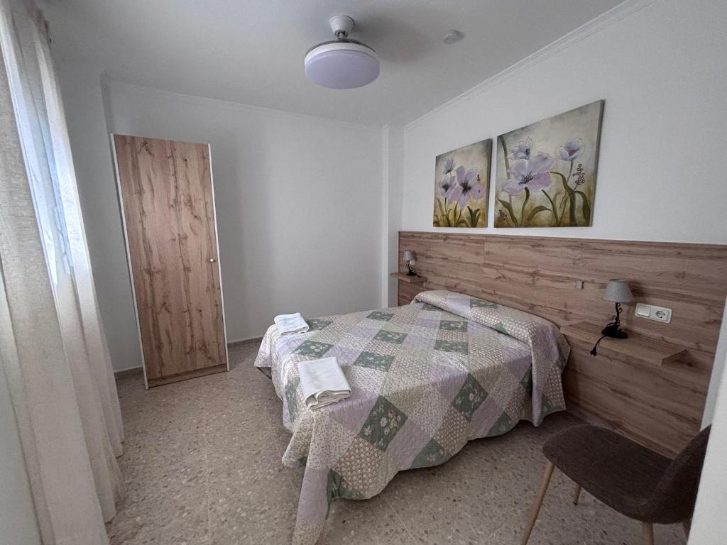 a bedroom with a bed and a painting on the wall at Hostal Gutierrez in Ceuta
