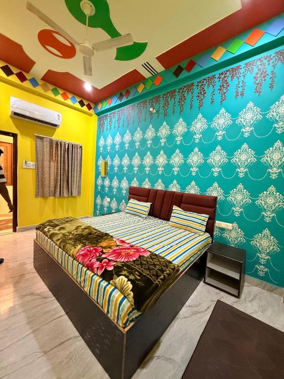 a bedroom with a bed with a colorful wall at Keshav Vatika Palace - 800 meter Ram Mandir in Ayodhya