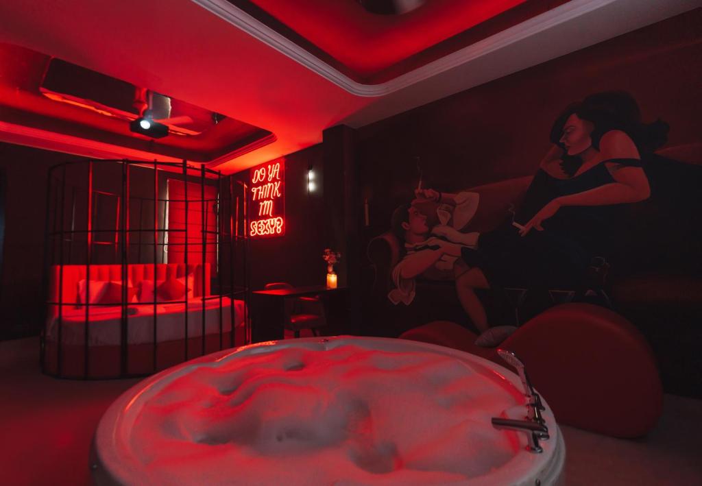 a red room with a tub and two people in it at Orsom Stay Rooms with Jacuzzi Sector 53 Gurgaon in Gurgaon