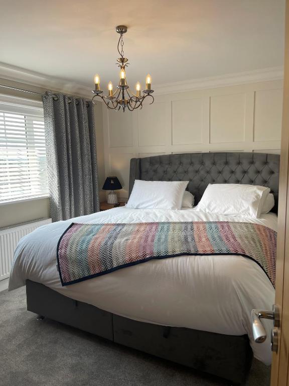 a bedroom with a large bed with a chandelier at Ambermay House in Armagh