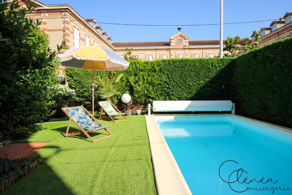 a swimming pool with an umbrella and a chair at Evasion in Albi