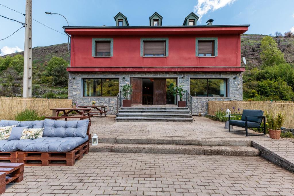 a red house with couches in front of it at La Casona de Omaña in Fasgar
