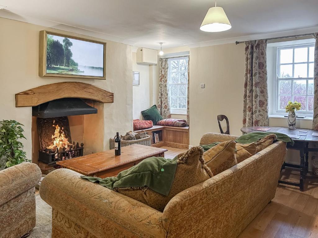 a living room with a couch and a fireplace at Foumartdean Cottage in Town Yetholm