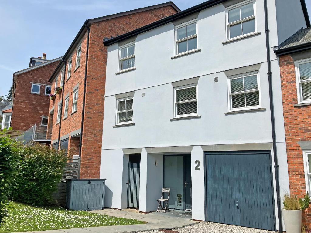 a white building with a garage and a door at Eddystone Row 2 in Salcombe