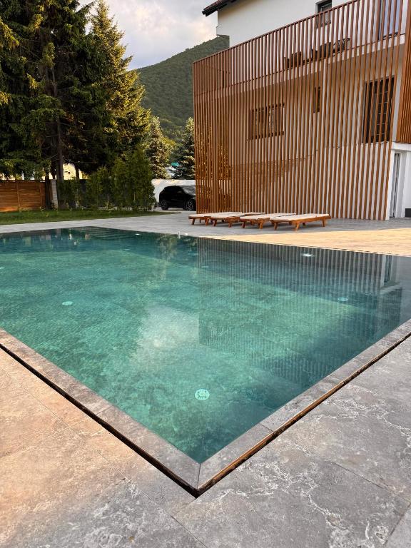 a swimming pool in front of a house at Villa-Vista di Pini Sarajevo in Sarajevo