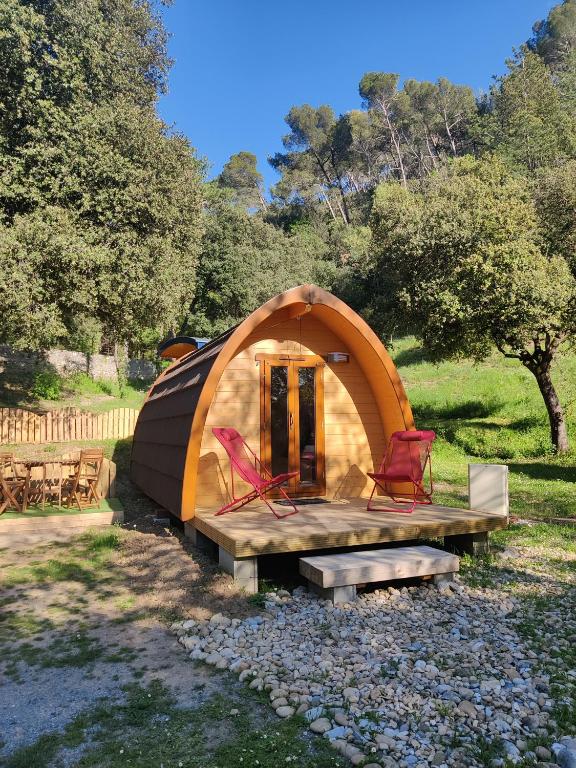 a dome tent with two chairs and a bench at Hébergements Insolites Camping la Pinède des Mées in Les Mées