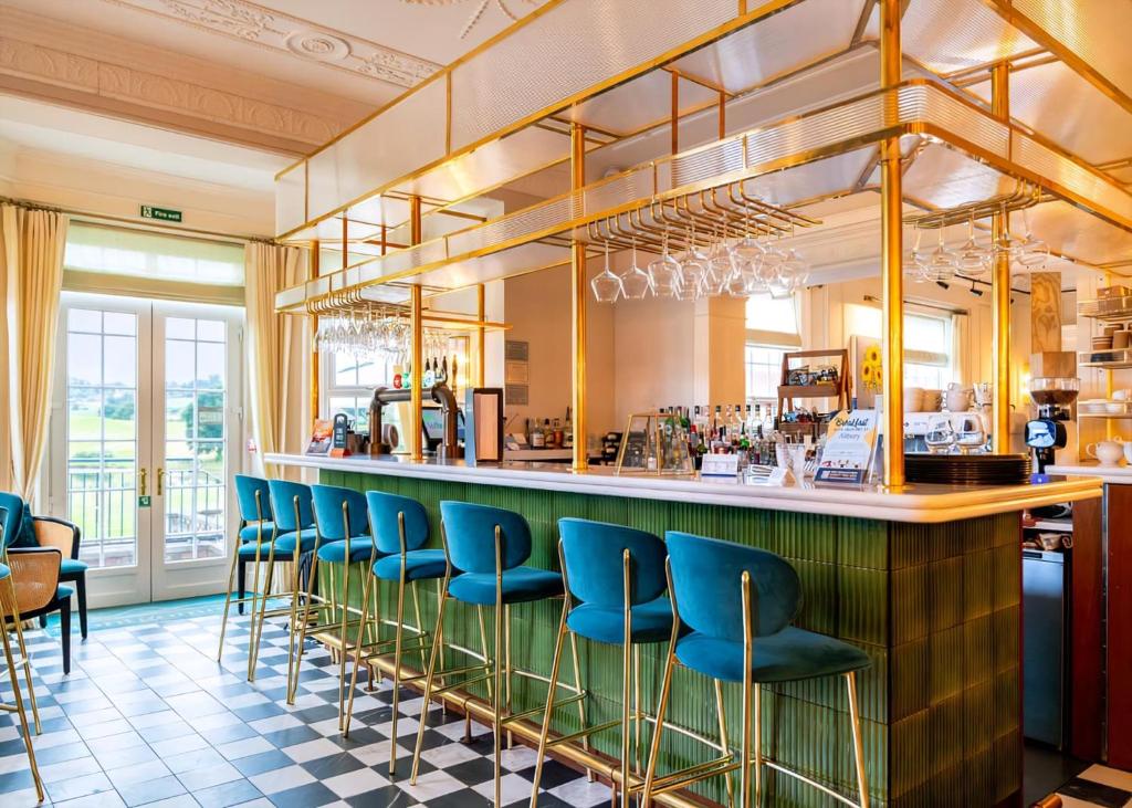 a bar with blue chairs at a restaurant at The Astbury Golf And Lodge Resort in Bridgnorth