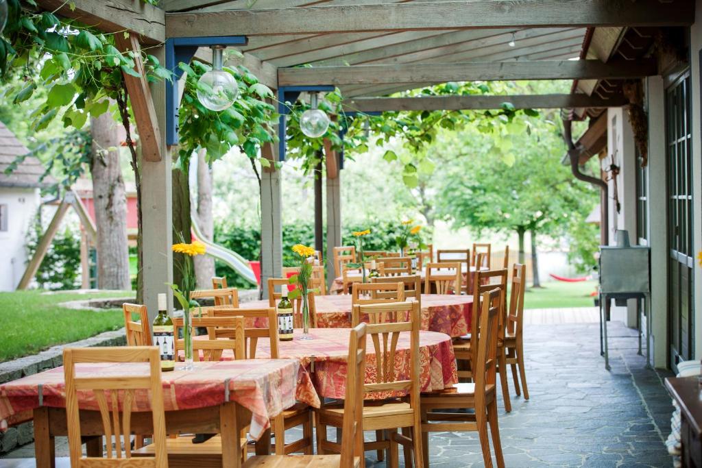eine Reihe von Tischen und Stühlen auf einer Terrasse in der Unterkunft Landhotel Schwabenhof in Heiligenbrunn