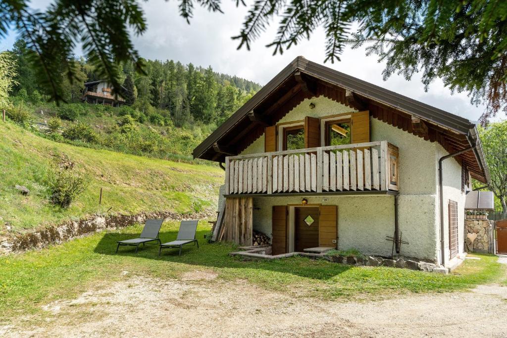 a small house with two chairs in front of it at Baita Dal Bigolaro in Levico Terme