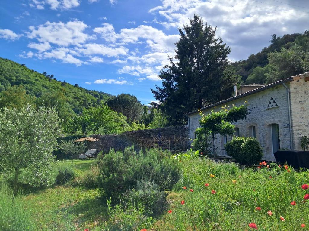 an old stone house in a field of flowers at Les Jardins du Bateau in Vals-les-Bains