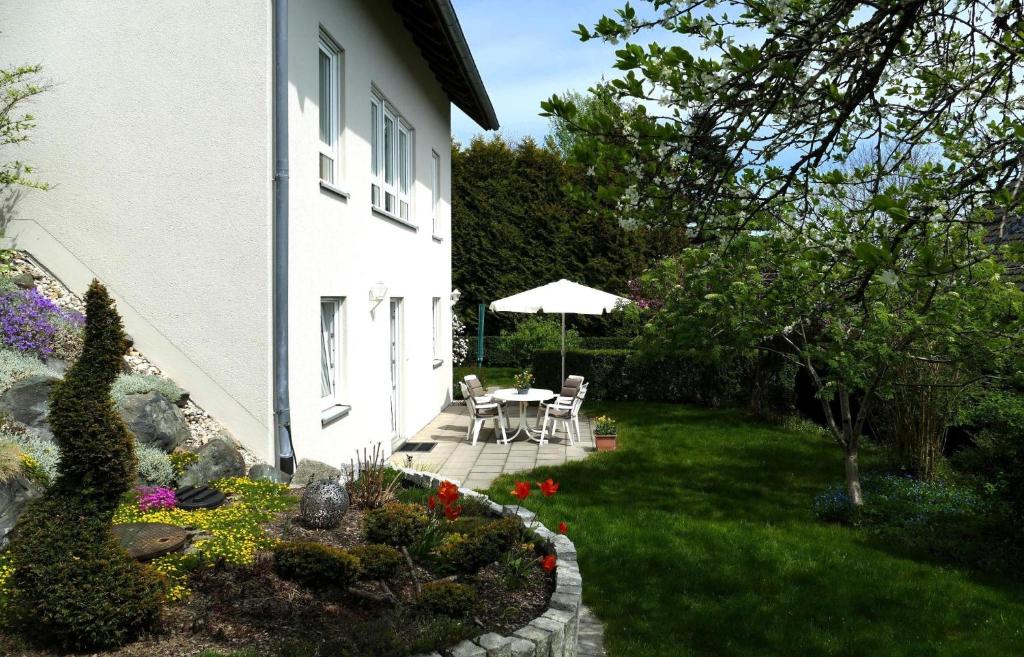 a garden with a table and chairs next to a building at Ferienwohnung Meyer in Schönwald