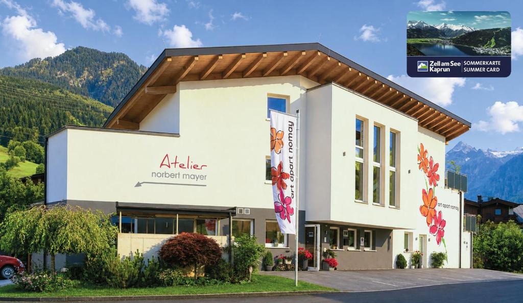 a building with a sign for a hotel at Art Apart Nomay Summercard Blick Top of Salzburg in Kaprun