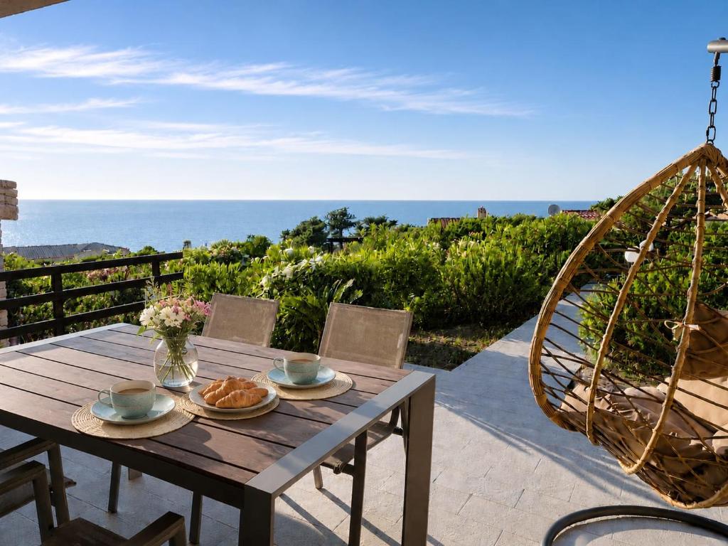 a wooden table with plates of food on a patio at Villetta Vista Paradiso in Costa Paradiso