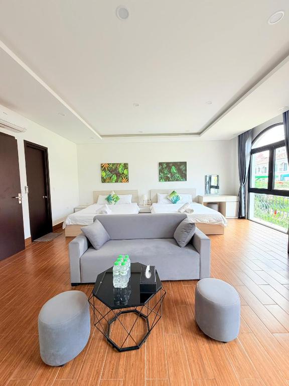 a living room with a couch and two beds at Tropical Bay Villas and Homestay in Phú Quốc