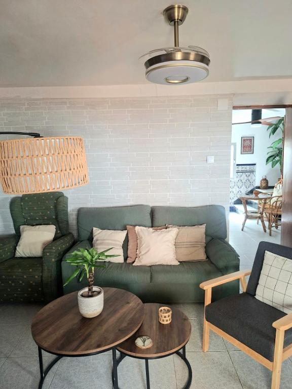 a living room with a green couch and a table at Casa de la abuelita in Cazorla