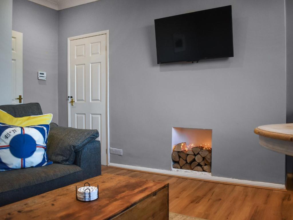 a living room with a couch and a fire place at Marina Views in Amble